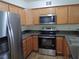 The kitchen features stainless appliances, stone counters and light wood cabinets at 9325 W Desert Inn Rd # 110, Las Vegas, NV 89117