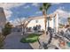 Backyard featuring a pool, gravel, short decorative grass area, outdoor furniture, and a two-story house at 9520 Wooden Pier Way, Las Vegas, NV 89117