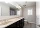 Bathroom featuring dual sinks, granite countertop, dark cabinets, and shower with decorative patterned curtain at 9520 Wooden Pier Way, Las Vegas, NV 89117
