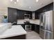 This modern kitchen offers black cabinets, stainless steel appliances, and a stone countertop island at 9520 Wooden Pier Way, Las Vegas, NV 89117