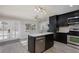 This kitchen features black cabinets, stainless steel appliances, and a stone countertop island at 9520 Wooden Pier Way, Las Vegas, NV 89117