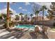 Inviting backyard showcasing a stunning pool, rock waterfall, mature trees and lounge chairs at 9520 Wooden Pier Way, Las Vegas, NV 89117