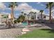 Backyard features a sparkling pool with a rock waterfall, lounge chairs and meticulous landscaping at 9520 Wooden Pier Way, Las Vegas, NV 89117