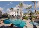 Rear exterior view of the home featuring a freeform pool, spa and mature palm trees at 9520 Wooden Pier Way, Las Vegas, NV 89117