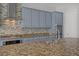 Elegant kitchen featuring granite countertops, stainless steel appliances, and a mosaic tile backsplash at 9779 Mosaic Canyon Ct, Las Vegas, NV 89149