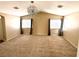 Bedroom featuring plush carpet, two windows, and a modern chandelier at 9792 Cordova Vista Ct, Las Vegas, NV 89183