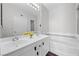 Bathroom featuring double sinks, soaking tub, framed mirror, and stylish vanity with dark hardware at 9901 Trailwood Dr # 2144, Las Vegas, NV 89134