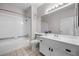Bright bathroom featuring a tub-shower combo, single sink vanity, toilet, and neutral ceramic tile flooring at 9901 Trailwood Dr # 2144, Las Vegas, NV 89134