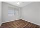 Bedroom featuring wood floors, a ceiling fan, and a large window at 9901 Trailwood Dr # 2144, Las Vegas, NV 89134