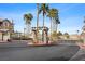A gated community entrance with meticulously maintained landscaping including tall palm trees at 9901 Trailwood Dr # 2144, Las Vegas, NV 89134