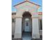 Arched front entryway featuring a security door, desert landscaping, and neutral colors at 9937 Villa Ridge Dr, Las Vegas, NV 89134