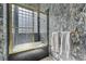 Elegant bathroom with unique wall coverings and finishes, tub, and glass block window at 10 Innisbrook Ave, Las Vegas, NV 89113