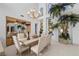 Bright dining room with a chandelier, high windows, and elegant furniture with a view to greenery outside at 10 Innisbrook Ave, Las Vegas, NV 89113