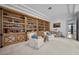 Well-lit library featuring custom bookshelves, a desk, and comfortable seating with a view to the hallway at 10 Innisbrook Ave, Las Vegas, NV 89113