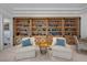 Cozy library featuring custom built-in bookshelves and two armchairs with table at 10 Innisbrook Ave, Las Vegas, NV 89113