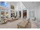 Bright living room with high ceilings and large windows, featuring elegant furniture and decor and bookshelves at 10 Innisbrook Ave, Las Vegas, NV 89113