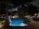 Tranquil nighttime view of the pool with landscape lighting, creating a relaxing ambiance at 10 Innisbrook Ave, Las Vegas, NV 89113
