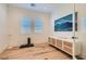 Bright workout room featuring two windows, hardwood floors, and white media cabinet at 10239 Meandering Dell Ave, Las Vegas, NV 89166