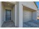 Inviting entrance featuring a covered doorway, stone accents, and a two-car garage, blending style and functionality at 10239 Meandering Dell Ave, Las Vegas, NV 89166
