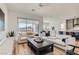 Open-concept living room flows seamlessly into the kitchen, enhanced by stylish furniture and lots of natural light at 10239 Meandering Dell Ave, Las Vegas, NV 89166