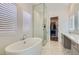 Luxurious main bathroom featuring soaking tub, glass shower and walk-in closet at 10239 Meandering Dell Ave, Las Vegas, NV 89166