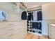 Spacious walk-in closet featuring custom shelving, drawers, and hardwood floors at 10239 Meandering Dell Ave, Las Vegas, NV 89166