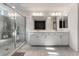 Modern bathroom with dual sinks, white cabinets, and a glass-enclosed shower with tile surround at 10319 Santero Bay Ct, Las Vegas, NV 89141