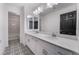 Bright bathroom with double vanity, framed mirrors, stylish floor and black door at 10319 Santero Bay Ct, Las Vegas, NV 89141