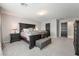 Well-lit main bedroom suite featuring an accent bench, black doors, and neutral carpet at 10319 Santero Bay Ct, Las Vegas, NV 89141