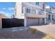 Two car garage with paved driveway and black iron fence at 10319 Santero Bay Ct, Las Vegas, NV 89141
