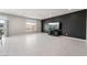 Bright living room with large windows, tile floors, and modern entertainment center at 10319 Santero Bay Ct, Las Vegas, NV 89141