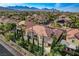 Aerial view of desert community with mountain views featuring lush landscaping and well-maintained properties at 10671 Capesthorne Way, Las Vegas, NV 89135
