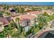 Aerial view of home with a pool, lush trees, and surrounding neighborhood in a desert setting at 10671 Capesthorne Way, Las Vegas, NV 89135