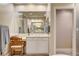 Bright bathroom vanity area featuring a large mirror, white cabinets, and a doorway to the shower at 10671 Capesthorne Way, Las Vegas, NV 89135