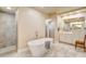 Well-lit bathroom boasts a soaking tub, a walk-in shower, and vanity with white cabinets at 10671 Capesthorne Way, Las Vegas, NV 89135