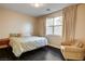 Comfortable bedroom with plush armchair, dark flooring and light-filtering curtains at 10671 Capesthorne Way, Las Vegas, NV 89135