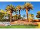 Landscaped community entrance with stone accents and lush palm trees at 10671 Capesthorne Way, Las Vegas, NV 89135