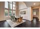 Elegant dining room with high ceilings, large windows, modern chandelier, and hardwood flooring at 10671 Capesthorne Way, Las Vegas, NV 89135