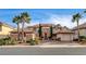 Beautiful two-story home with palm trees, manicured landscaping, and a circular driveway at 10671 Capesthorne Way, Las Vegas, NV 89135