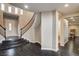 Grand foyer features dark wood floors, curved staircase, and lots of natural light at 10671 Capesthorne Way, Las Vegas, NV 89135
