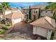 Stunning home exterior featuring a three-car garage, tile roof, palm trees and a manicured front yard at 10671 Capesthorne Way, Las Vegas, NV 89135