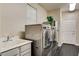 Functional laundry room with modern washer and dryer, sink, and storage space at 10671 Capesthorne Way, Las Vegas, NV 89135