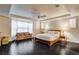 Spacious main bedroom features hardwood floors, ceiling fan, and a cozy sitting area by a large window at 10671 Capesthorne Way, Las Vegas, NV 89135