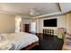 Large main bedroom featuring hardwood floors, ceiling fan, walk-in closet, TV, and seating area at 10671 Capesthorne Way, Las Vegas, NV 89135