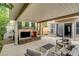 A covered patio with a stone fireplace and comfortable seating offers an inviting outdoor living space at 10671 Capesthorne Way, Las Vegas, NV 89135