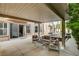 An outdoor patio featuring comfortable seating area, fireplace, and views of the pool and lush landscaping at 10671 Capesthorne Way, Las Vegas, NV 89135