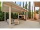 A covered outdoor patio features a fireplace, seating area, and manicured landscaping at 10671 Capesthorne Way, Las Vegas, NV 89135