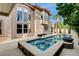 Beautiful backyard pool and spa with lounge chairs, palm trees, and privacy landscaping at 10671 Capesthorne Way, Las Vegas, NV 89135