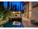 Backyard view showcasing the pool, landscaped border, and an outdoor fireplace at 10671 Capesthorne Way, Las Vegas, NV 89135