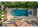 Aerial view of sparkling pool and spa surrounded by patio, lush landscaping, and lounge chairs at 10671 Capesthorne Way, Las Vegas, NV 89135